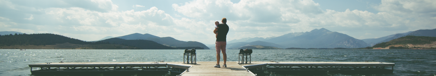 Father holding child on a dock