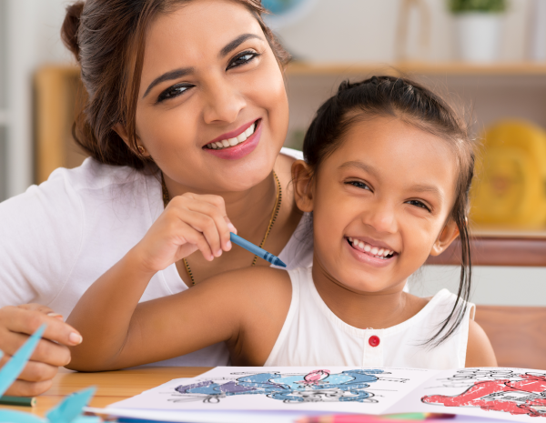 Mother and Daughter at table coloring in book